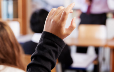 Student putting their hand up in class