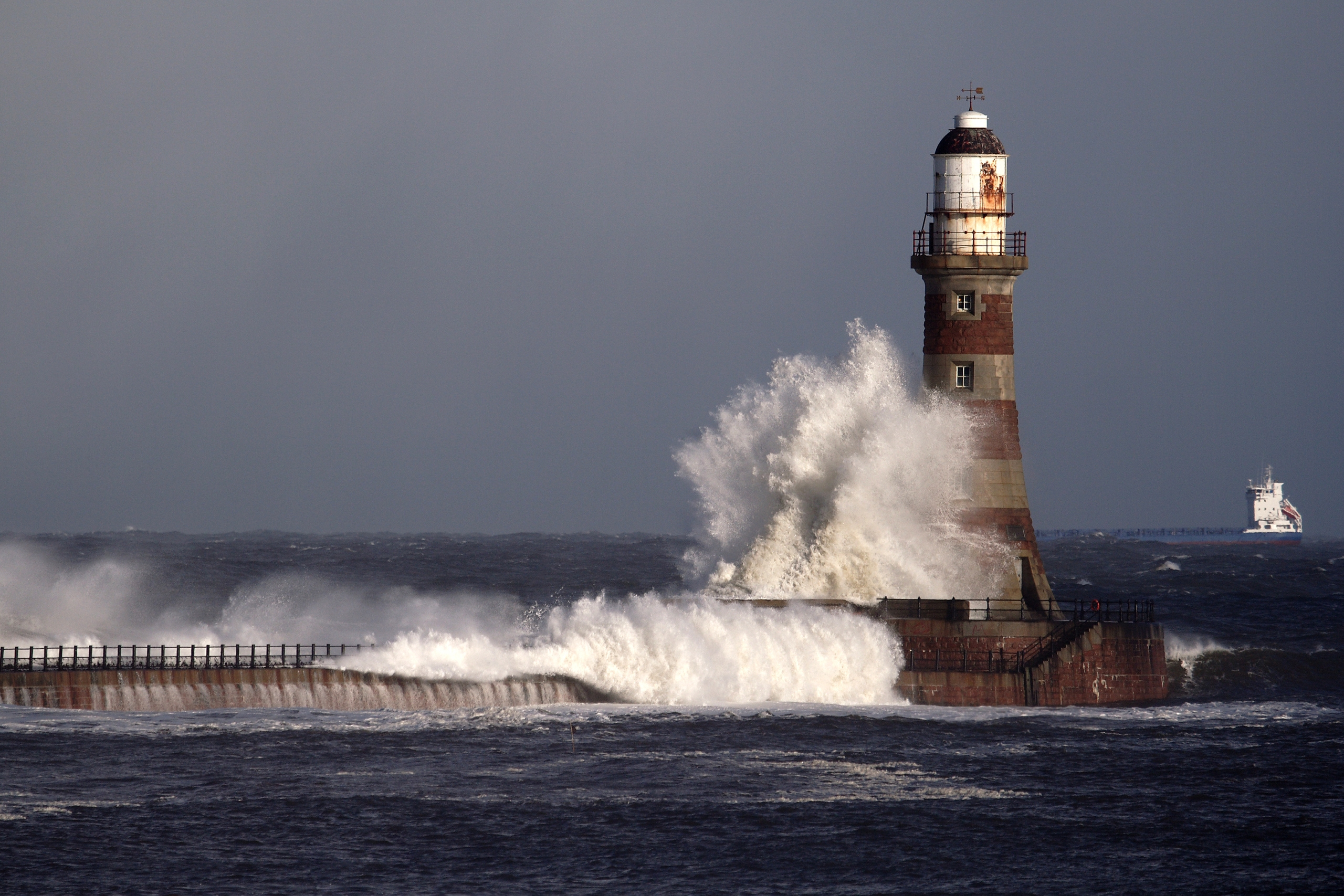 A wave crashing against a lighthouse