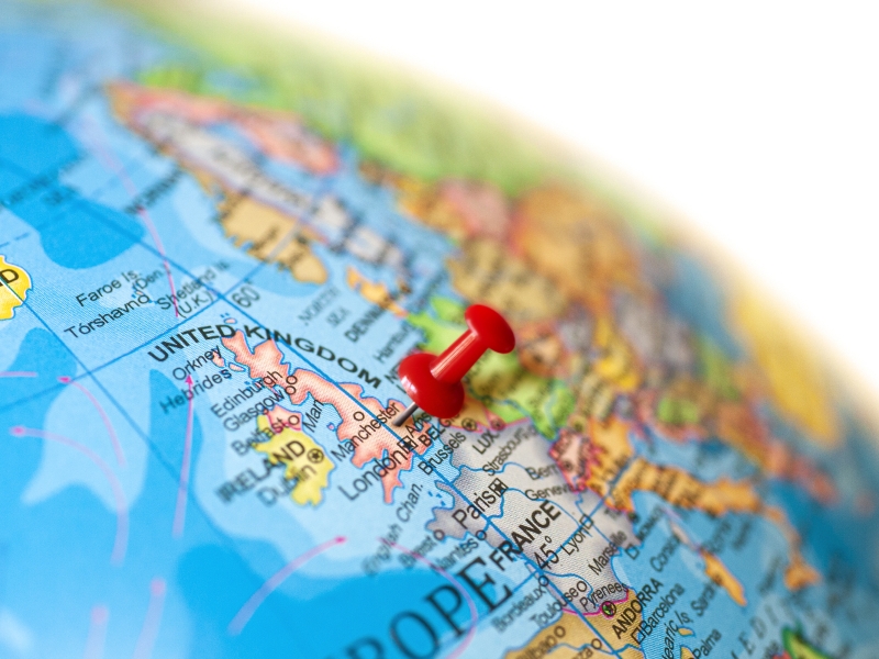 map of the world with a pin in Manchester
